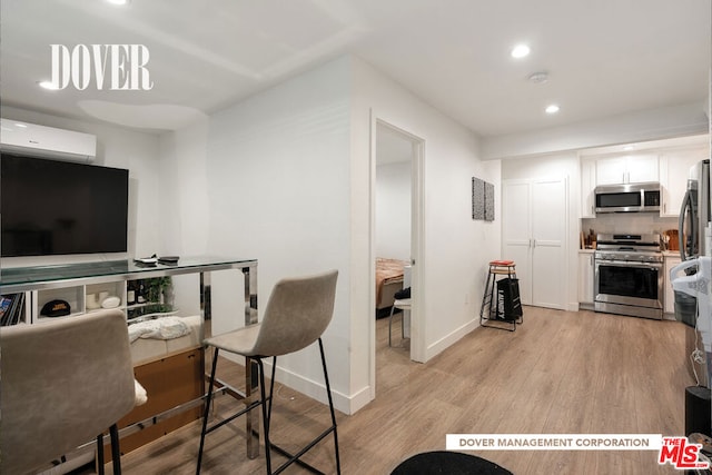 interior space featuring an AC wall unit and light hardwood / wood-style flooring