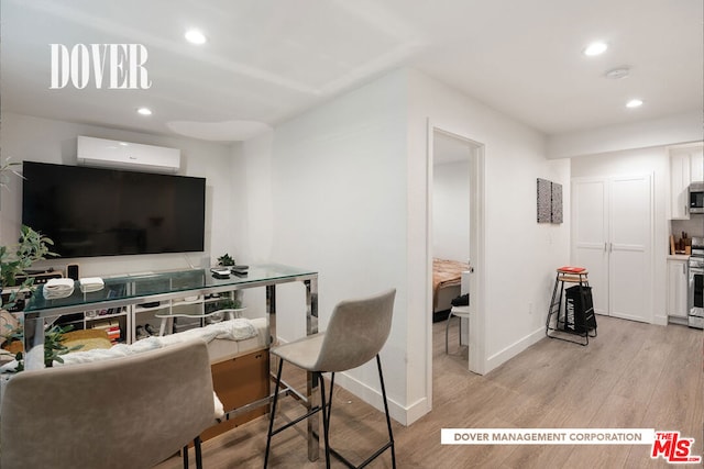 living room featuring light hardwood / wood-style flooring and a wall mounted air conditioner