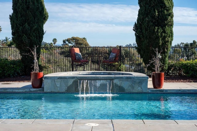 view of swimming pool featuring pool water feature and a jacuzzi