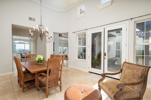 tiled dining area featuring a towering ceiling and a chandelier