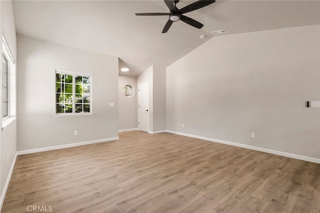 spare room with ceiling fan, vaulted ceiling, and light wood-type flooring