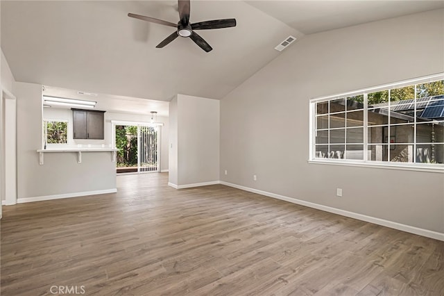 unfurnished living room featuring ceiling fan, wood-type flooring, and vaulted ceiling