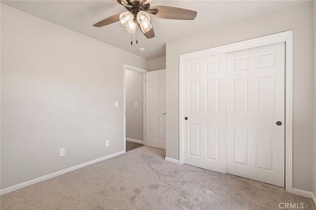 unfurnished bedroom featuring light carpet, a closet, and ceiling fan