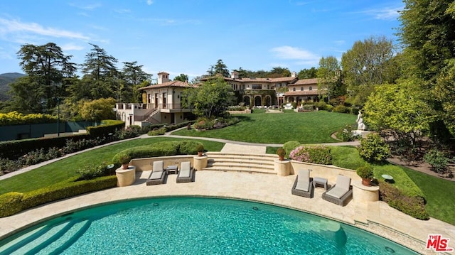 view of swimming pool featuring a lawn and a patio