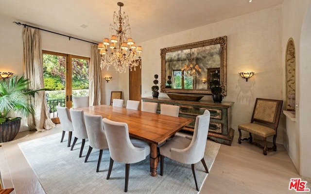 dining room featuring an inviting chandelier, light hardwood / wood-style flooring, and french doors