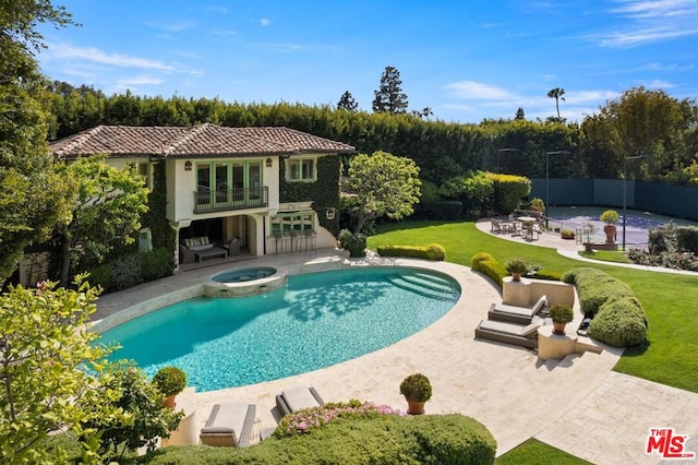 view of pool with an in ground hot tub, a yard, and a patio