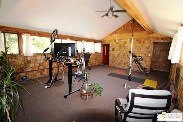 exercise area with ceiling fan, wooden walls, lofted ceiling, and carpet flooring