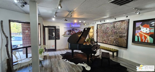 misc room featuring hardwood / wood-style floors, track lighting, and a wall mounted AC