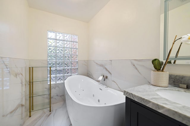 bathroom featuring lofted ceiling, vanity, tile walls, and a bathing tub