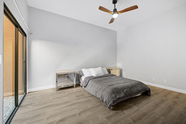 bedroom with access to exterior, light hardwood / wood-style floors, and ceiling fan