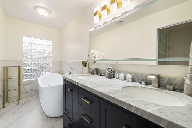 bathroom with vanity, tile walls, and a bathing tub