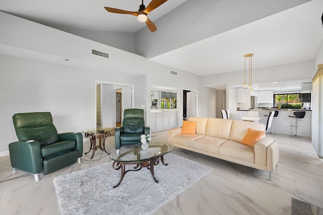 living room with ceiling fan and high vaulted ceiling