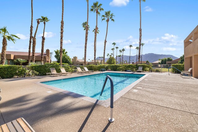 view of swimming pool with a patio area and a mountain view