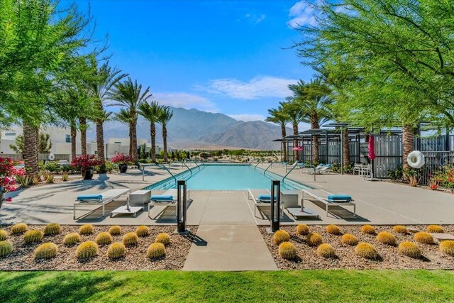 view of swimming pool with a patio area and a mountain view