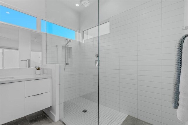 bathroom featuring tile patterned floors, a shower with door, and vanity