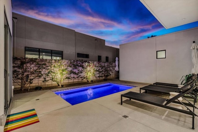 pool at dusk with a patio