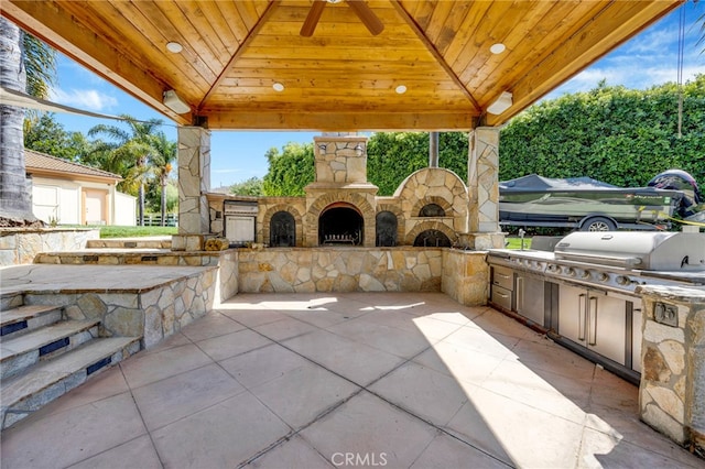 view of patio / terrace featuring area for grilling, a gazebo, and an outdoor stone fireplace