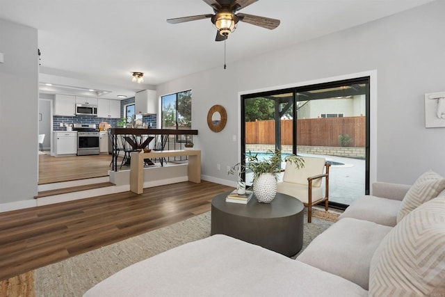 living room featuring ceiling fan and dark hardwood / wood-style flooring