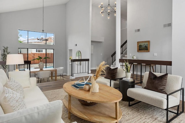 living room with a chandelier, hardwood / wood-style flooring, and high vaulted ceiling