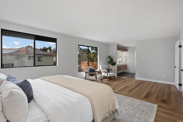 bedroom with wood-type flooring and connected bathroom