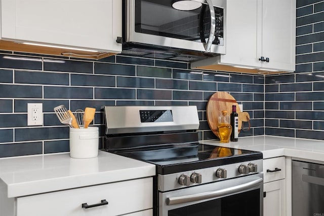 kitchen with decorative backsplash, white cabinetry, and appliances with stainless steel finishes