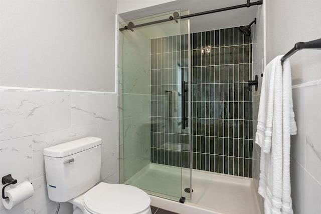 bathroom featuring walk in shower, toilet, and tile walls