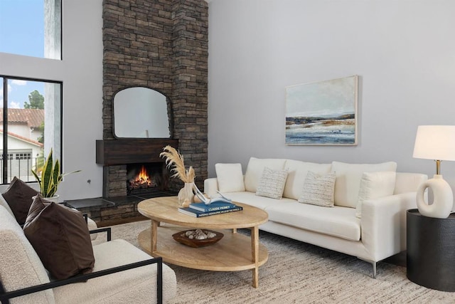 living room featuring a fireplace, wood-type flooring, and a high ceiling