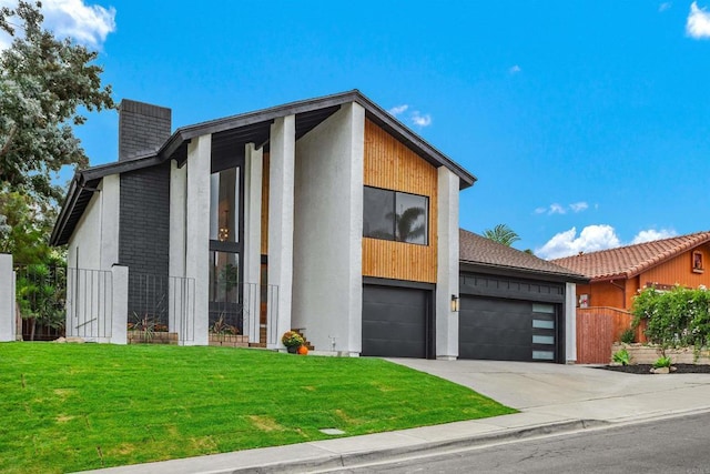 contemporary house featuring a front yard and a garage