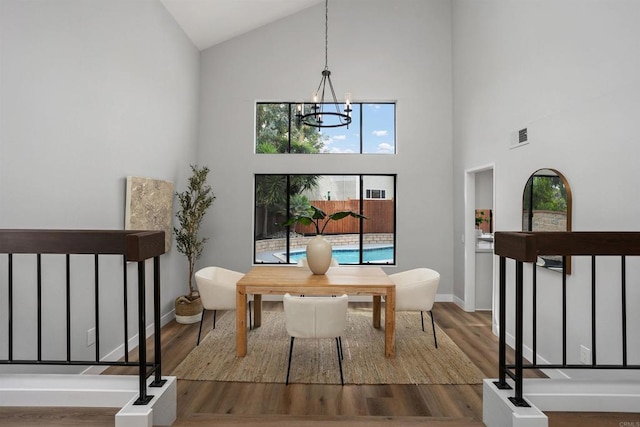 living area featuring a chandelier, wood-type flooring, and high vaulted ceiling