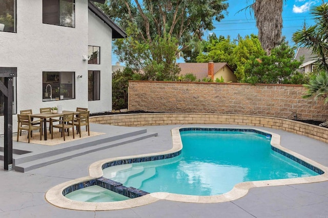 view of pool featuring a patio area and an in ground hot tub