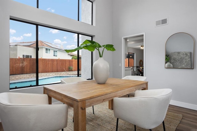 dining area with hardwood / wood-style flooring and a high ceiling