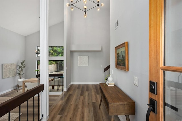 foyer entrance featuring high vaulted ceiling, a chandelier, and dark hardwood / wood-style floors