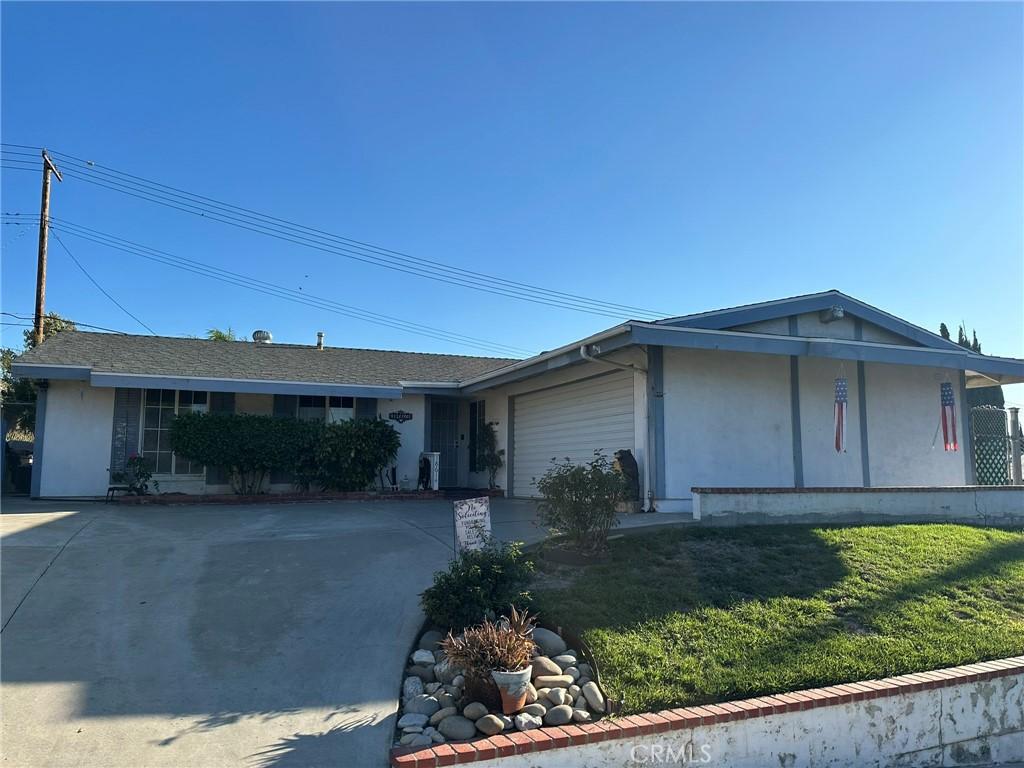 single story home with a front yard and a garage