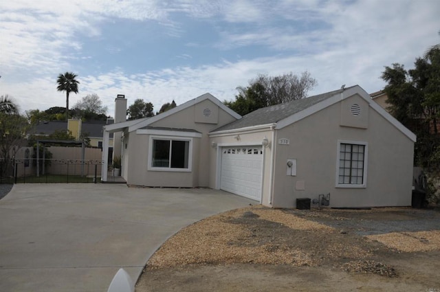 view of front facade with a garage, concrete driveway, and stucco siding