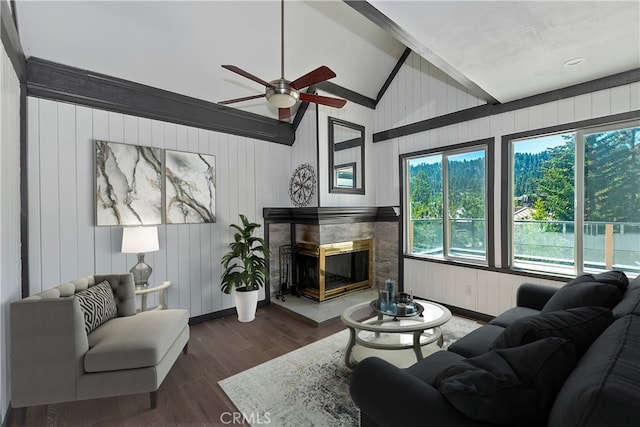 living room with ceiling fan, wood walls, dark wood-type flooring, and high vaulted ceiling