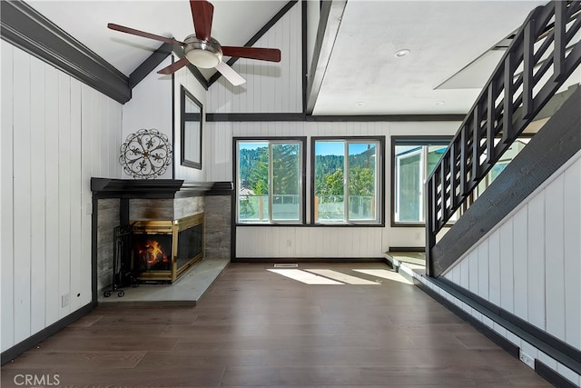 unfurnished living room with ceiling fan, wooden walls, a multi sided fireplace, and dark hardwood / wood-style flooring