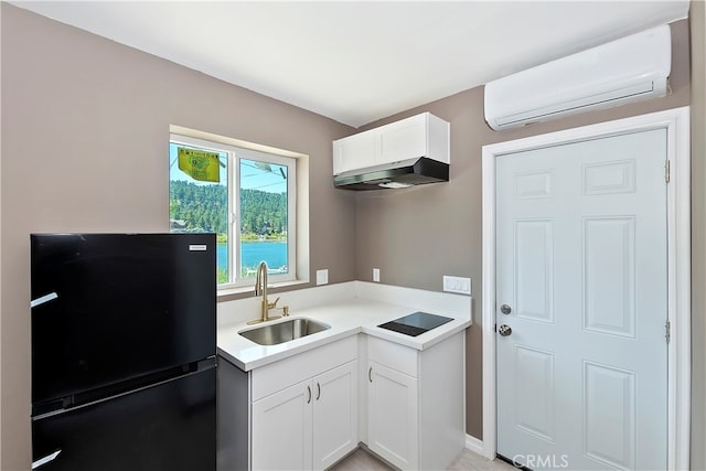 kitchen featuring an AC wall unit, white cabinets, black appliances, and sink