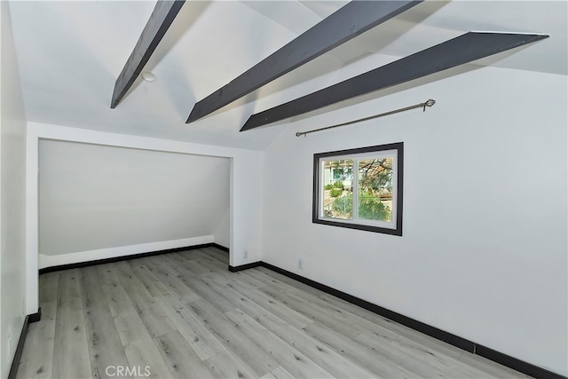 empty room with vaulted ceiling with beams and light hardwood / wood-style floors