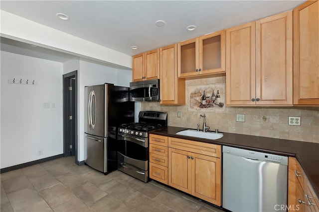 kitchen with light brown cabinetry, backsplash, appliances with stainless steel finishes, and sink