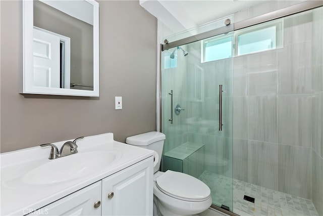 bathroom featuring vanity, toilet, and a shower with shower door