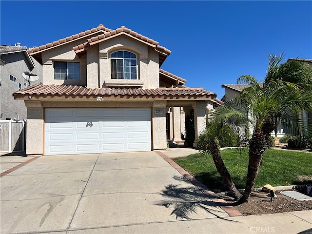 mediterranean / spanish-style home featuring a front lawn and a garage