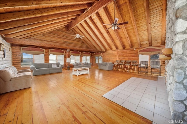 unfurnished living room with beam ceiling, light hardwood / wood-style flooring, high vaulted ceiling, ceiling fan, and wooden ceiling