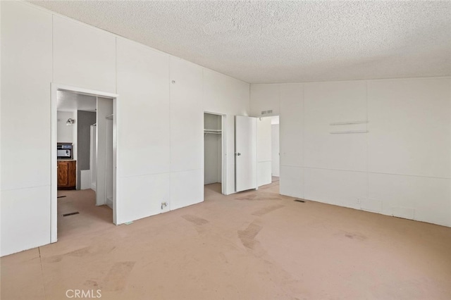 unfurnished bedroom featuring a textured ceiling and concrete floors