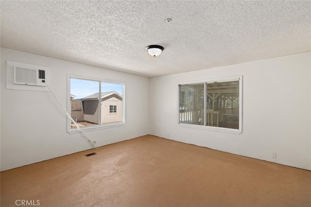 unfurnished room featuring a textured ceiling, carpet, and a wall unit AC