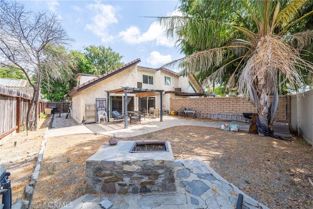 back of property featuring a pergola, a patio area, and a fire pit