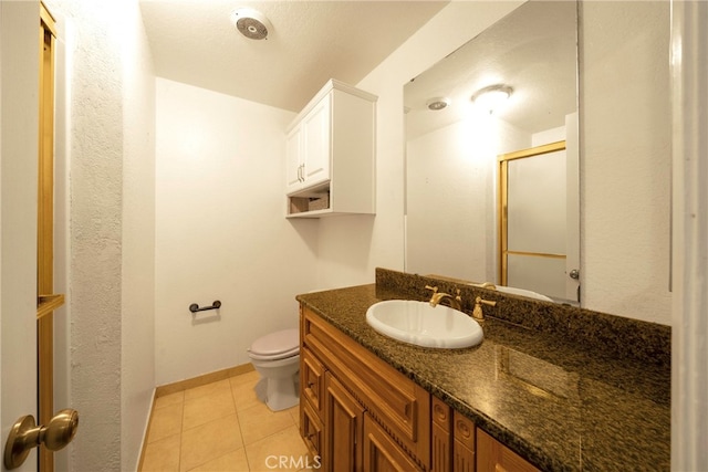 bathroom featuring walk in shower, vanity, toilet, and tile patterned floors