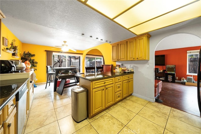 kitchen with dishwasher, a textured ceiling, light tile patterned flooring, kitchen peninsula, and ceiling fan