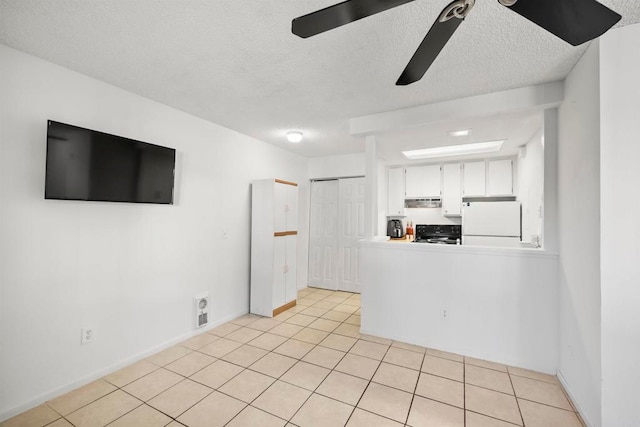 unfurnished living room featuring a textured ceiling, light tile patterned flooring, and ceiling fan