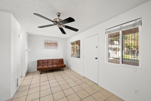 tiled foyer featuring ceiling fan and a textured ceiling