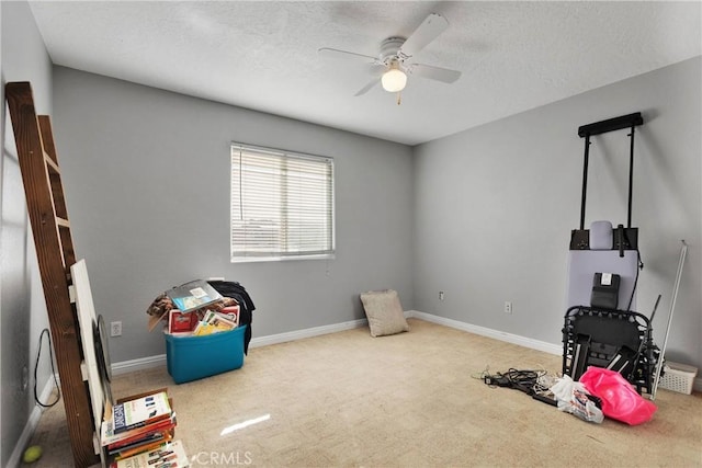 playroom with ceiling fan, light colored carpet, and a textured ceiling